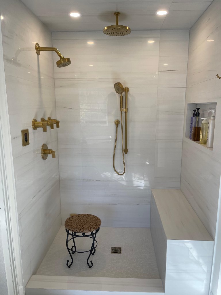 Luxury shower with gold fixtures and bench seat