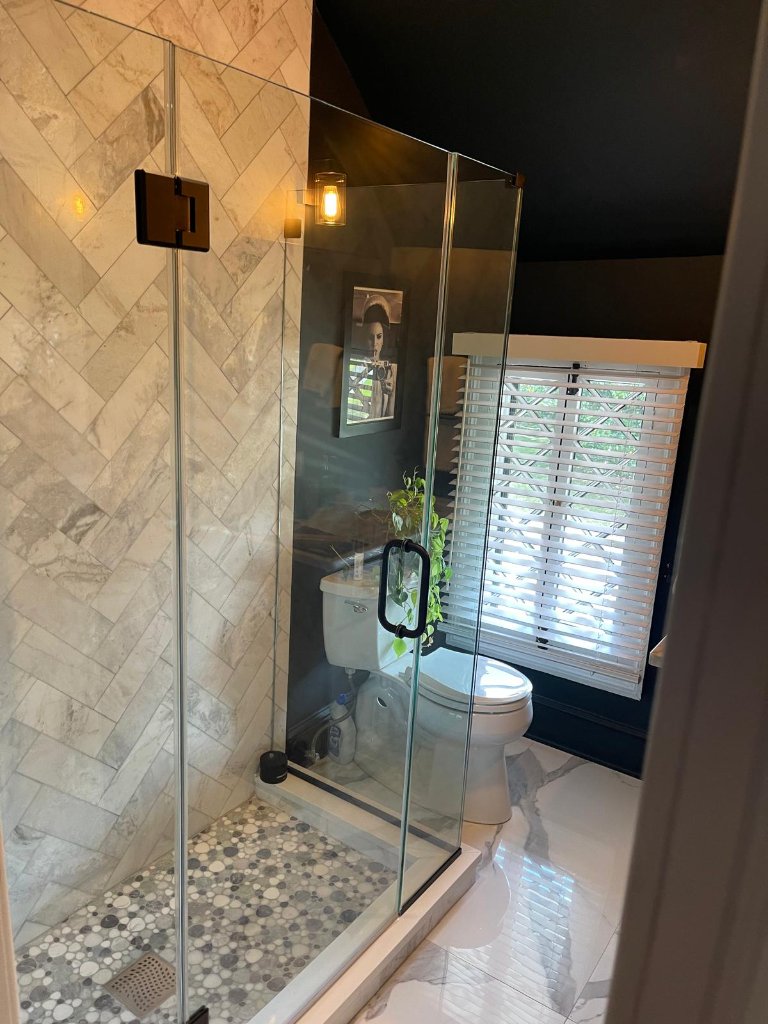 Marble herringbone shower with pebble floor