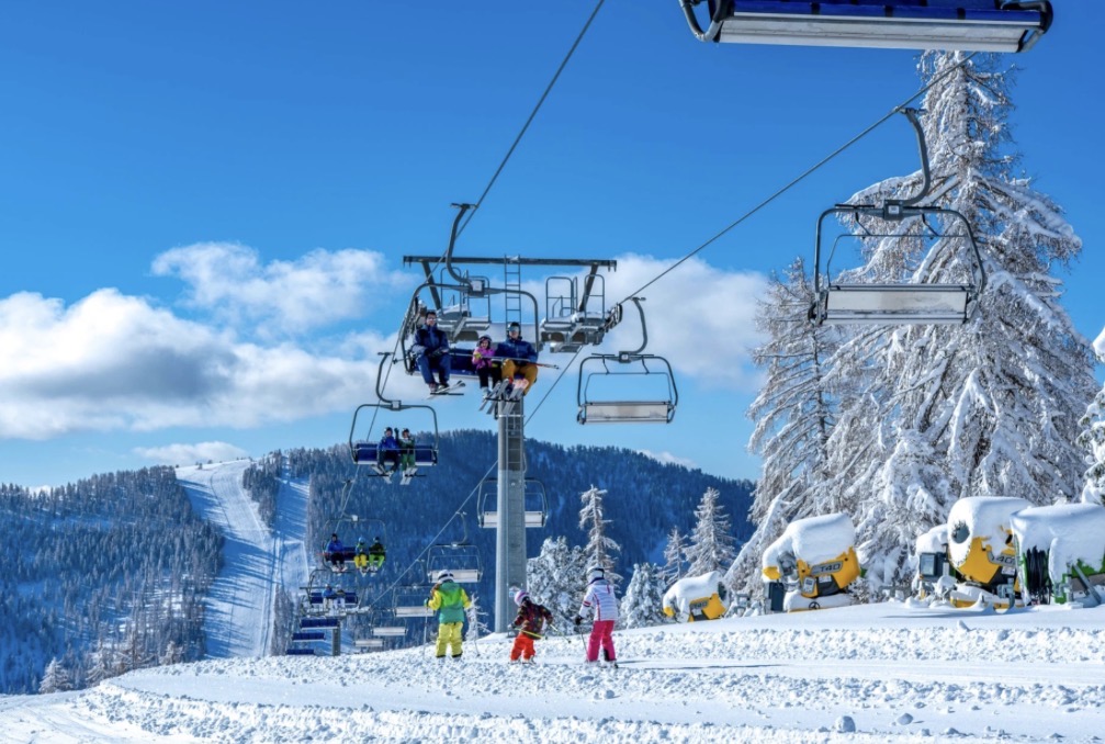 Skigebiet Hochrindl mit Lift und Skifahrern
