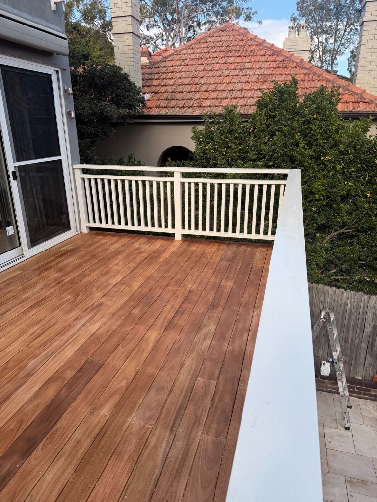 Completed raised Blackbutt deck with white balustrade open sky view over Sydney rooftops