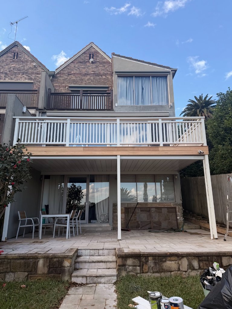 Raised Blackbutt timber deck with white balustrade and covered pergola in Sydney