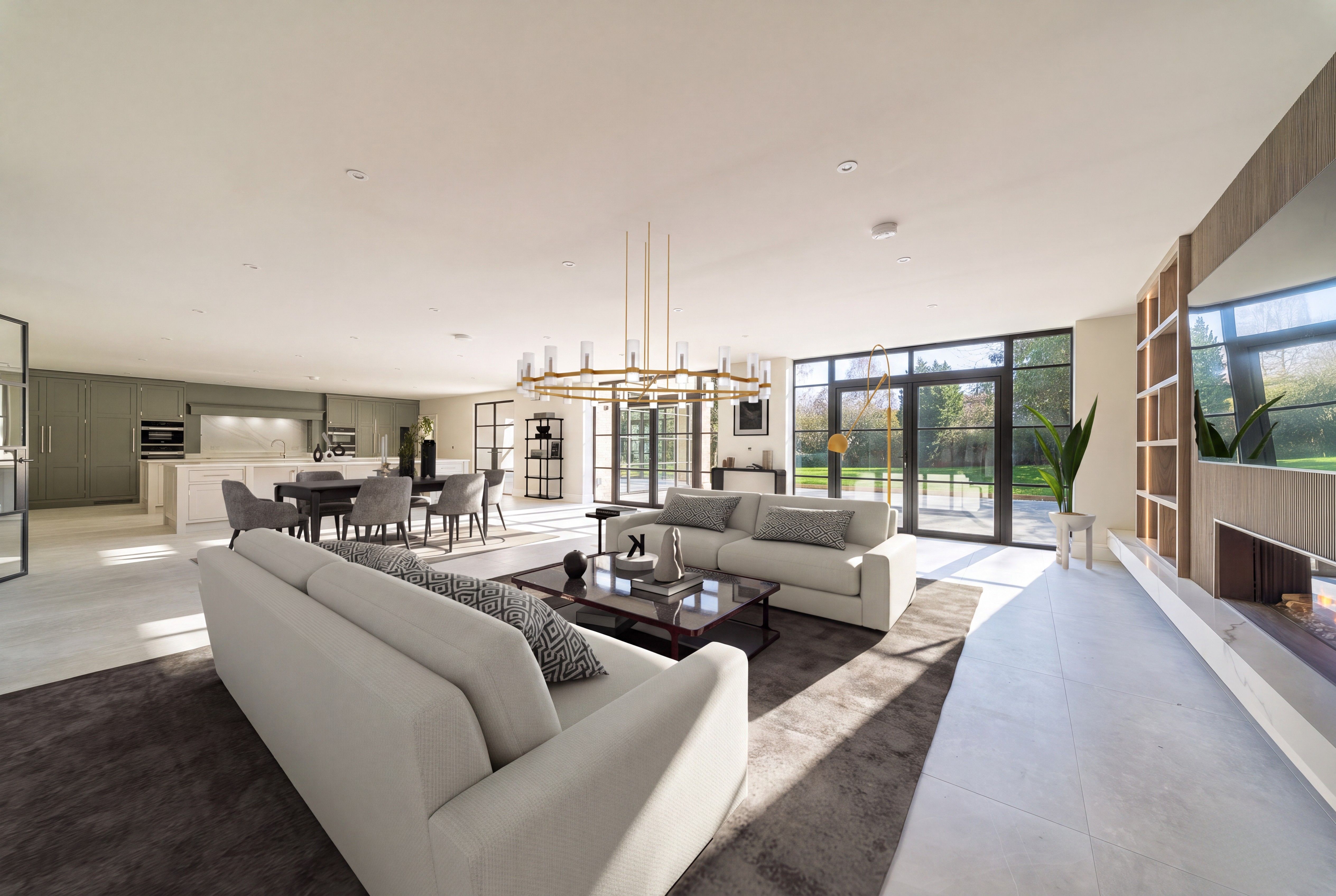 Digitally staged premium open-plan living room with cream sofas, dining area, kitchen and garden-facing glazing