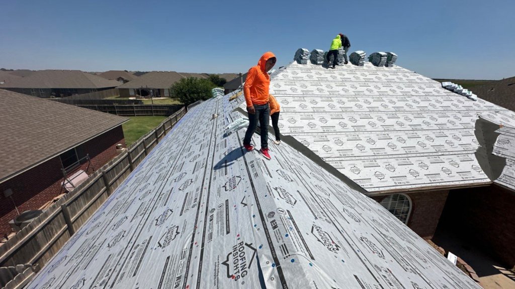 Crew laying synthetic underlayment
