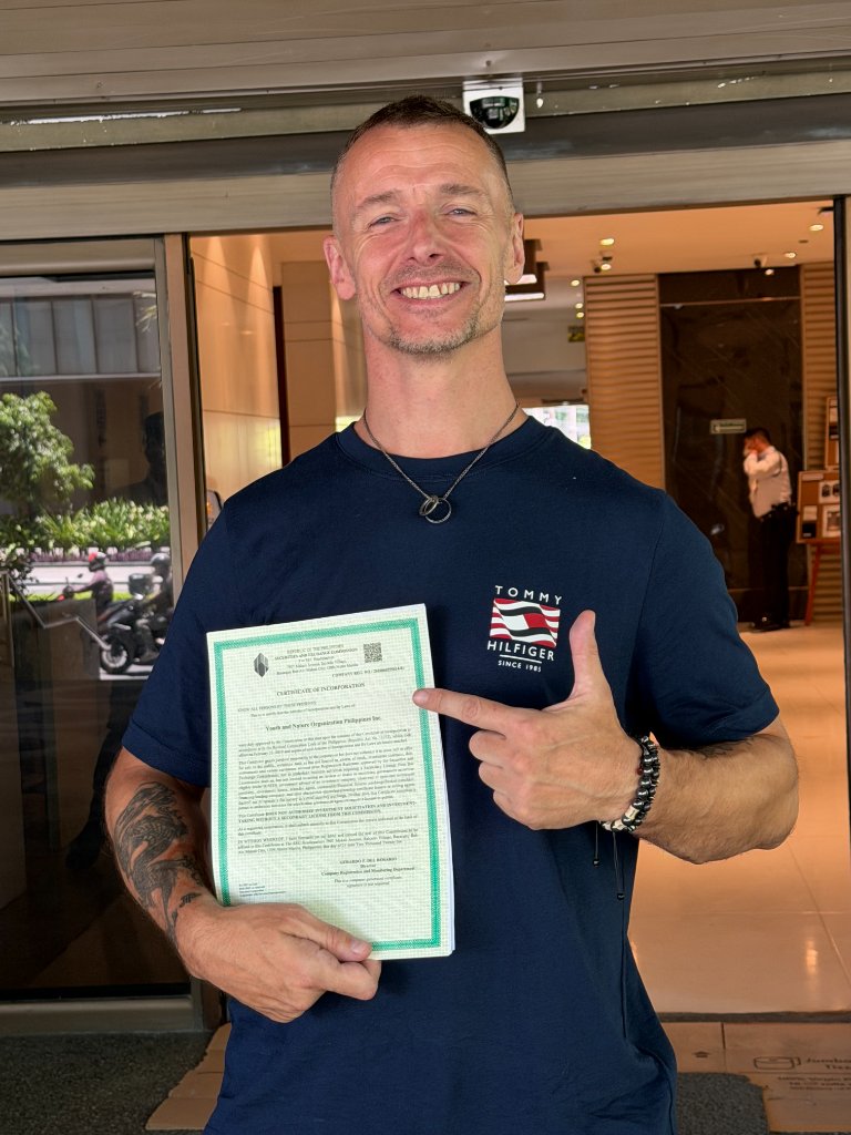 Ray Clark holding the Certificate of Incorporation from the Philippine Securities and Exchange Commission