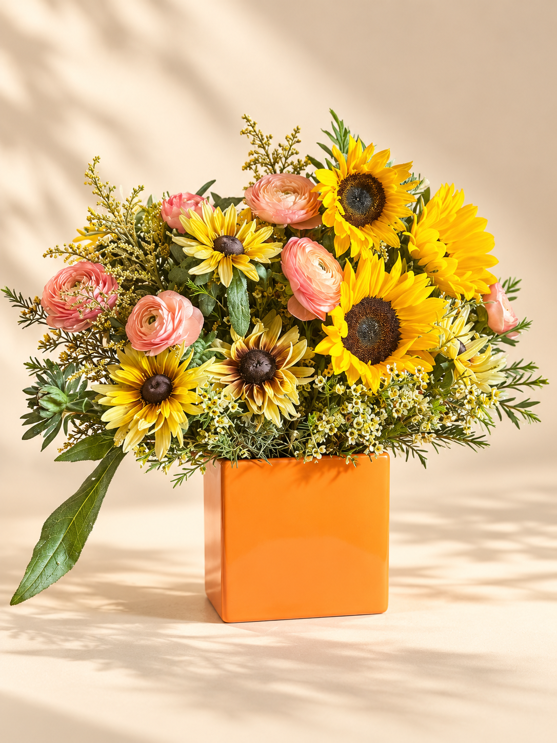 standard: Sunflowers and pink ranunculus arranged in a glossy orange ceramic vase for same-day flower delivery in Las Vegas NV — birthday and congratulations garden bouquet