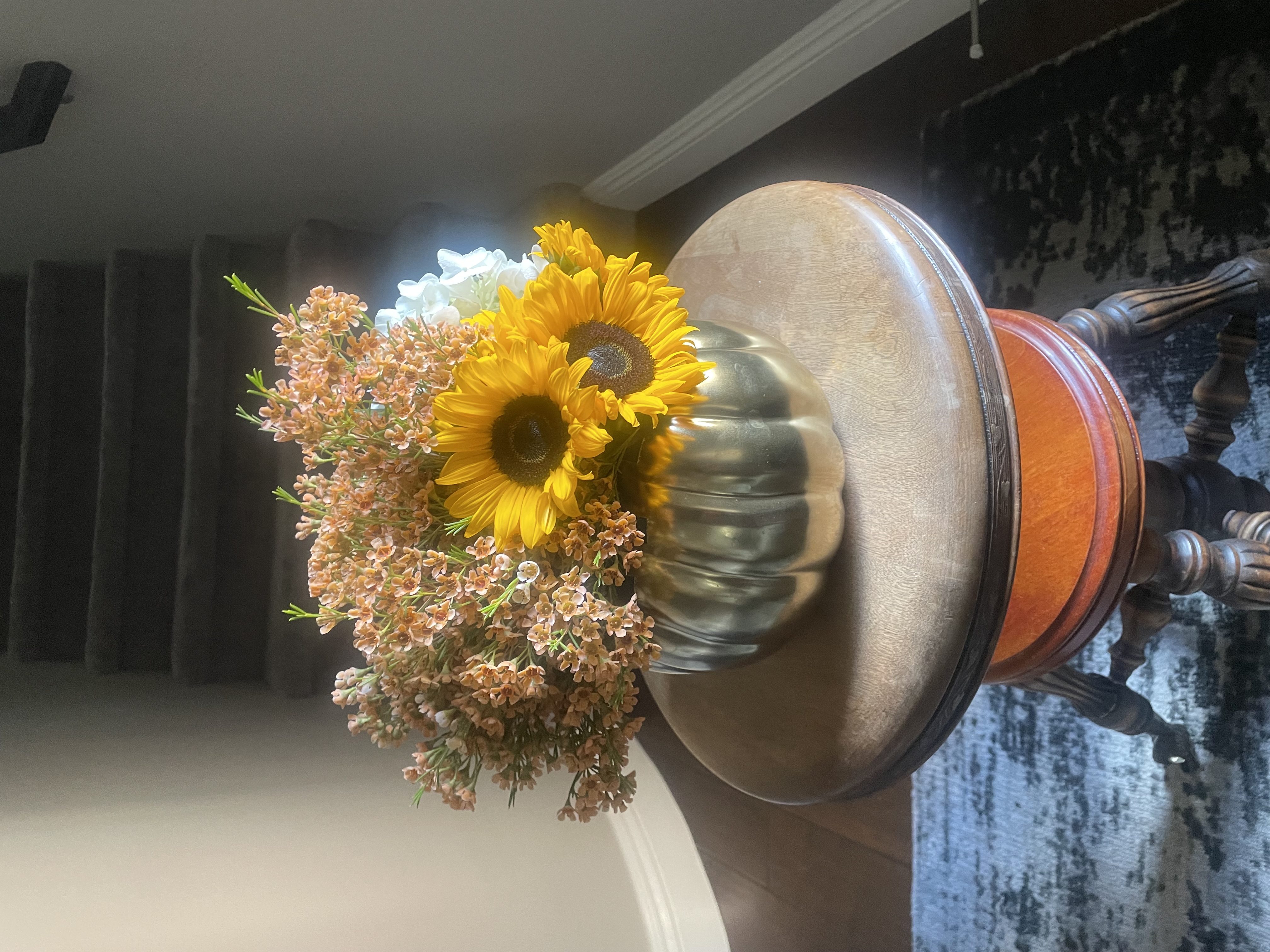 standard: Two bright yellow sunflowers with soft peach waxflower blossoms in a metallic gold pumpkin-shaped ceramic vase for fall flower delivery in Las Vegas Nevada