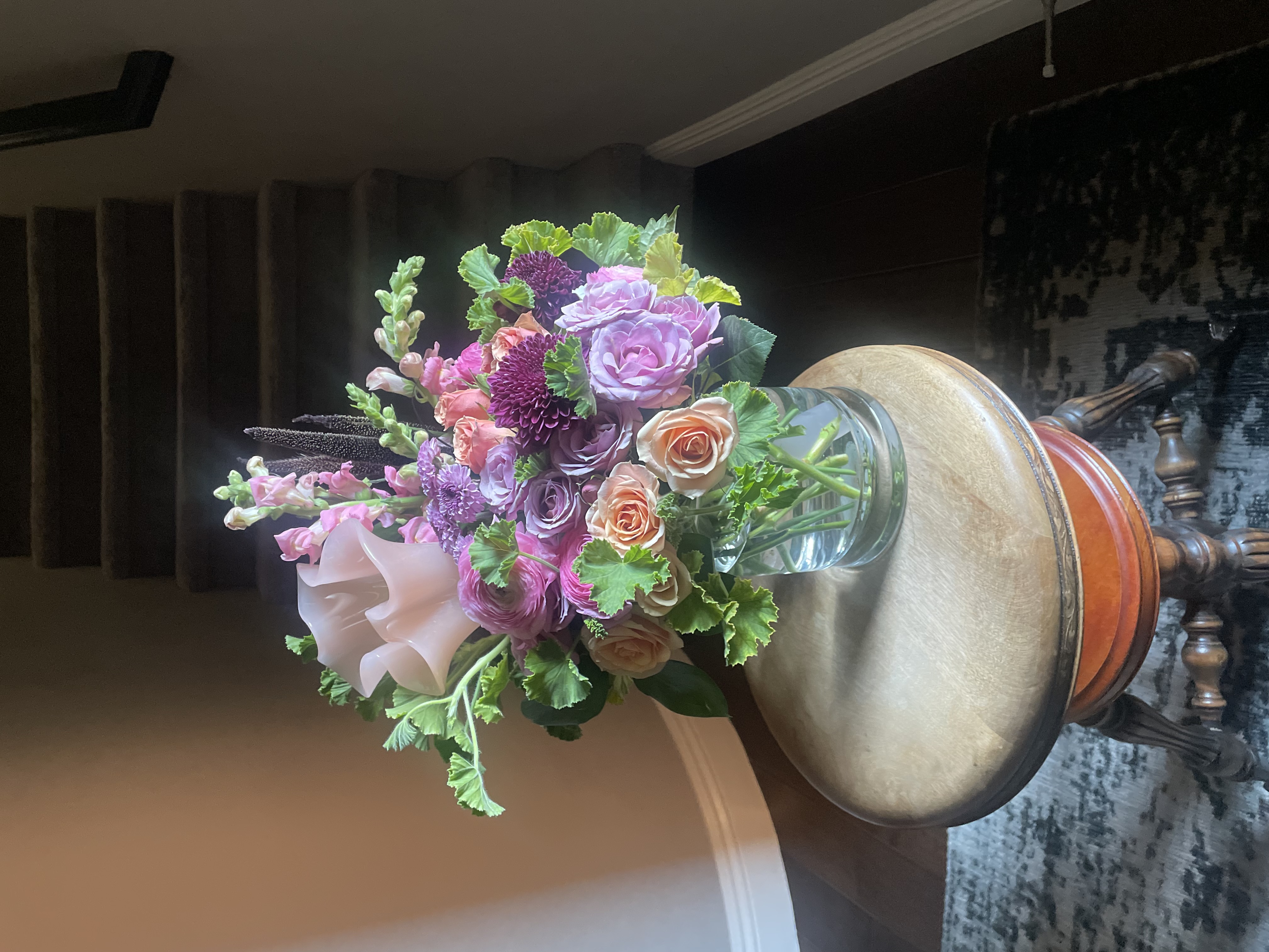 Standard Size — Lavender Dahlia & Rose Garden — Rose Arrangement Standard size Vibrant purple dahlia with soft lilac lavender roses and warm peach roses with lime green foliage and pale pink snapdragons in a clear cylindrical glass vase for modern luxury flower delivery in Las Vegas Nevada