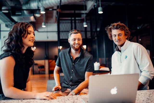 Team collaborating around a laptop