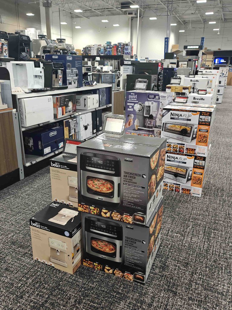 Stacked kitchen appliance boxes on retail floor — Bella and Ninja