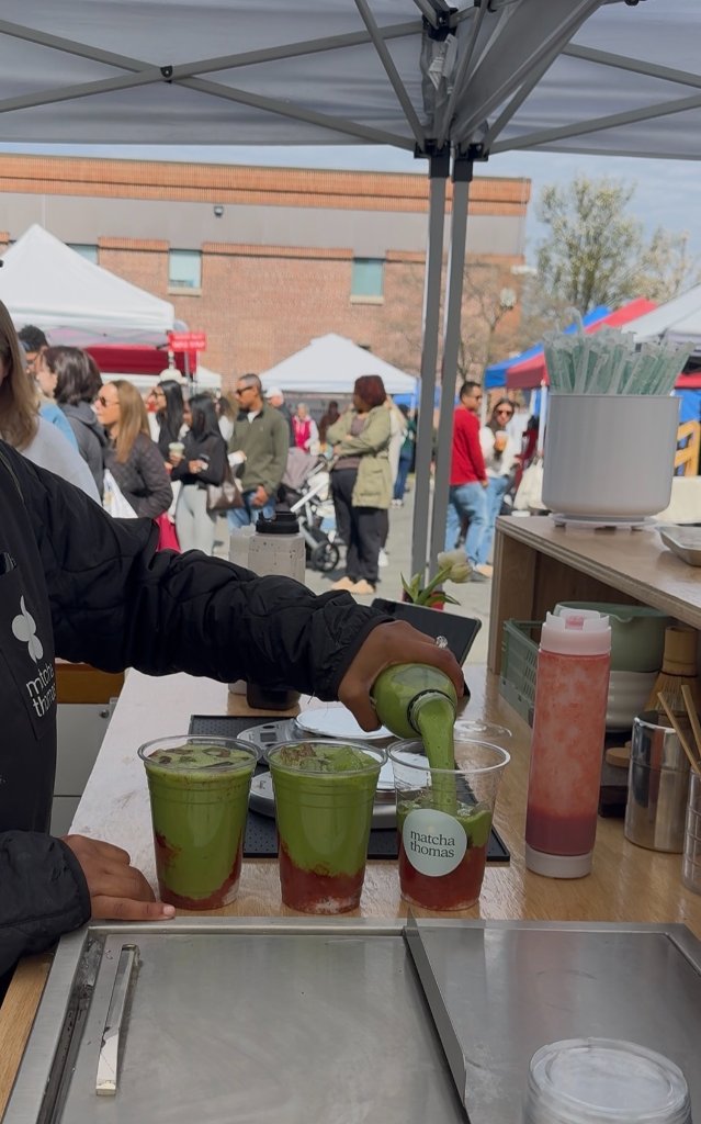 Vendor preparing beverages at market booth