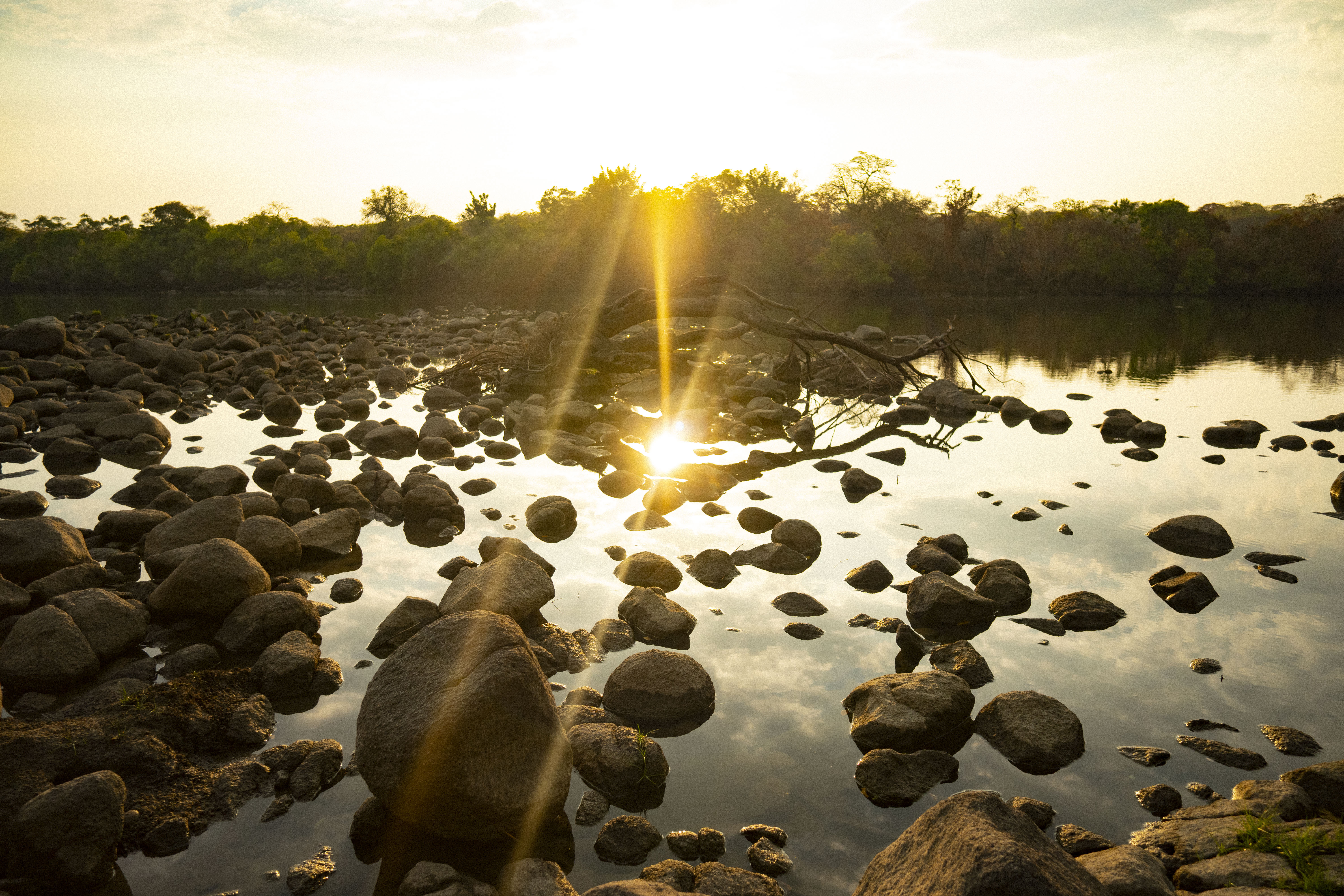 Sun setting over the rocky river shallows