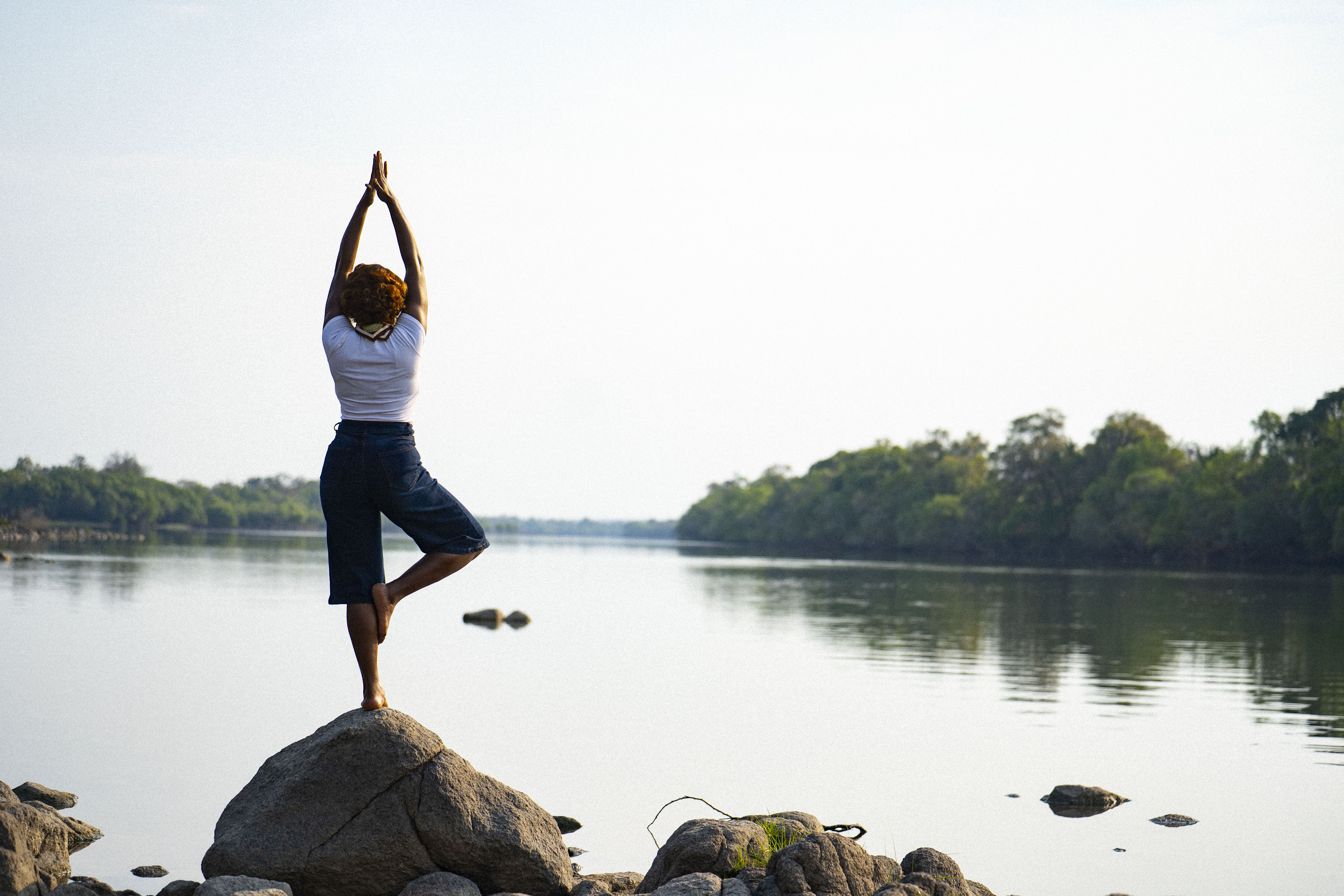 Riverside yoga on the rocks at sunrise