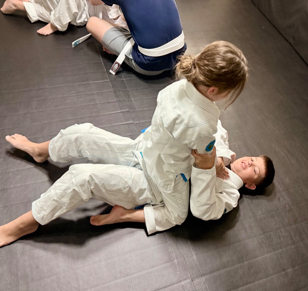 Garage Gators kids practicing Gracie Bullyproof® Jr. Combatives® techniques on the mat during a training session in Gainesville FL