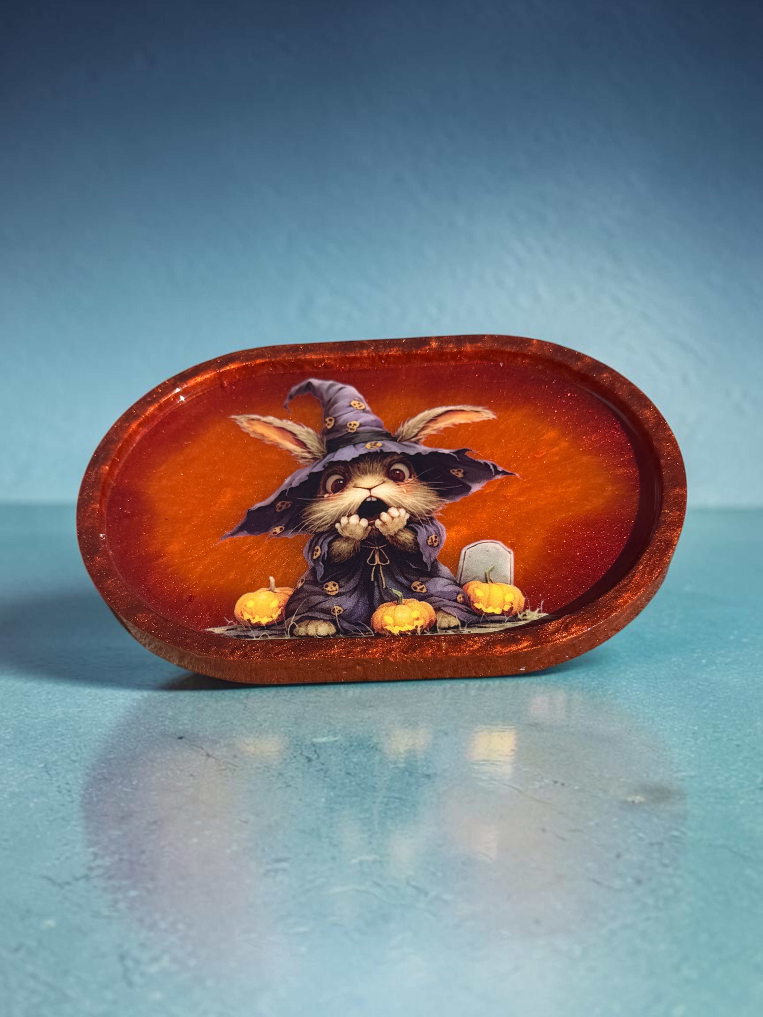 Bewitched Bunny Treat Tray - glossy pumpkin-orange resin tray with a whimsical witch-hat bunny, jack-o'-lanterns, and gold glitter accents