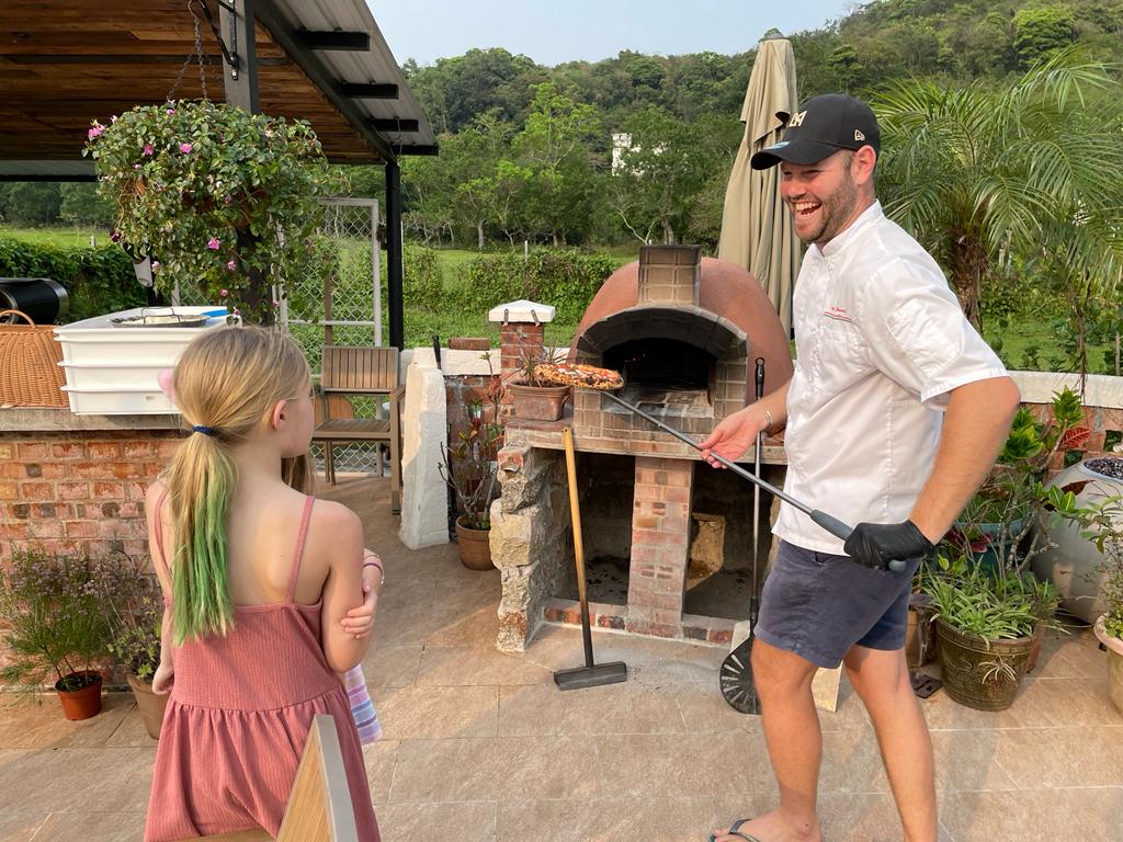 Pizza baking in the woodfire oven with flames