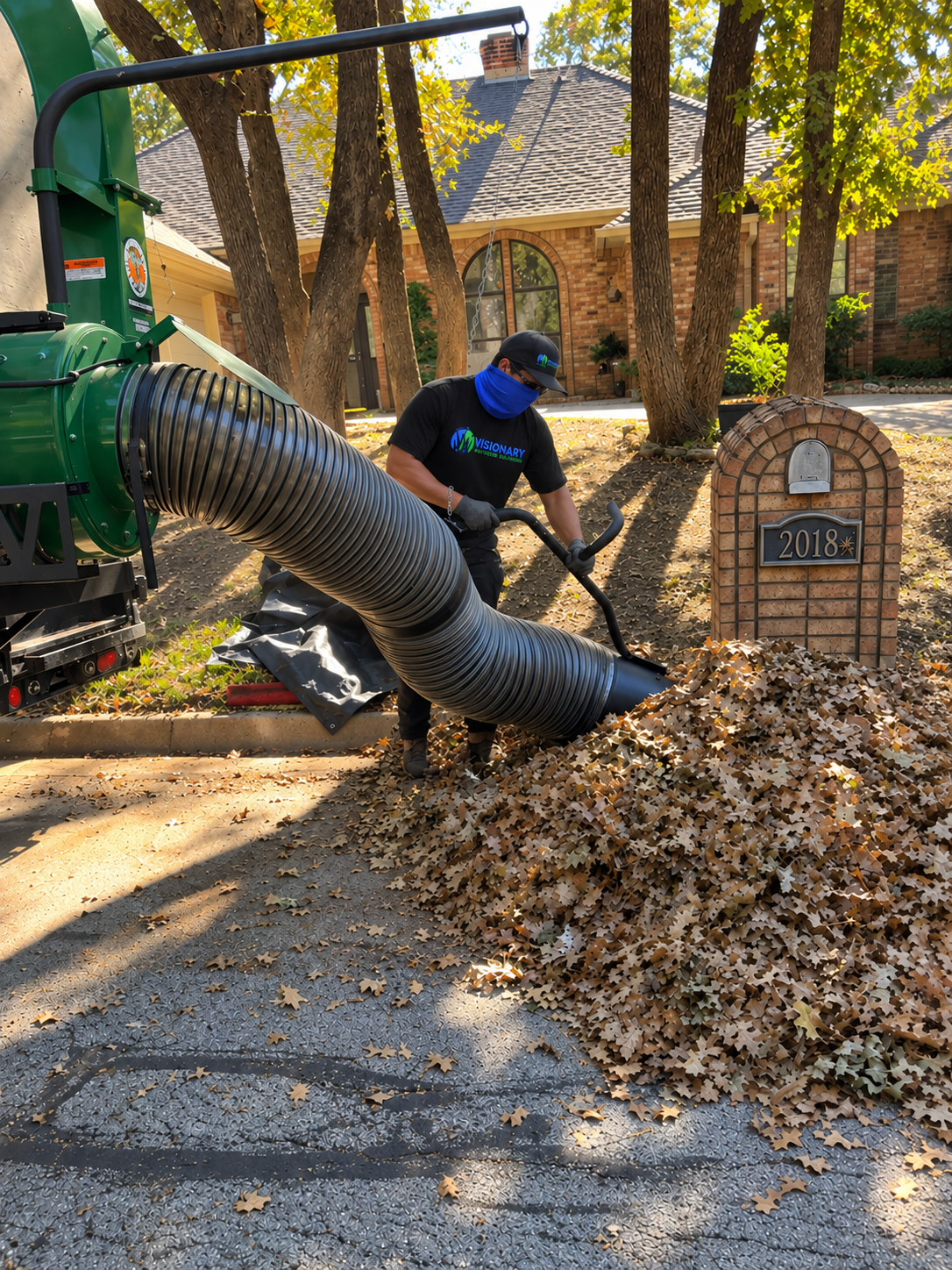 Visionary Outdoor Solutions crew vacuuming leaves at the curb