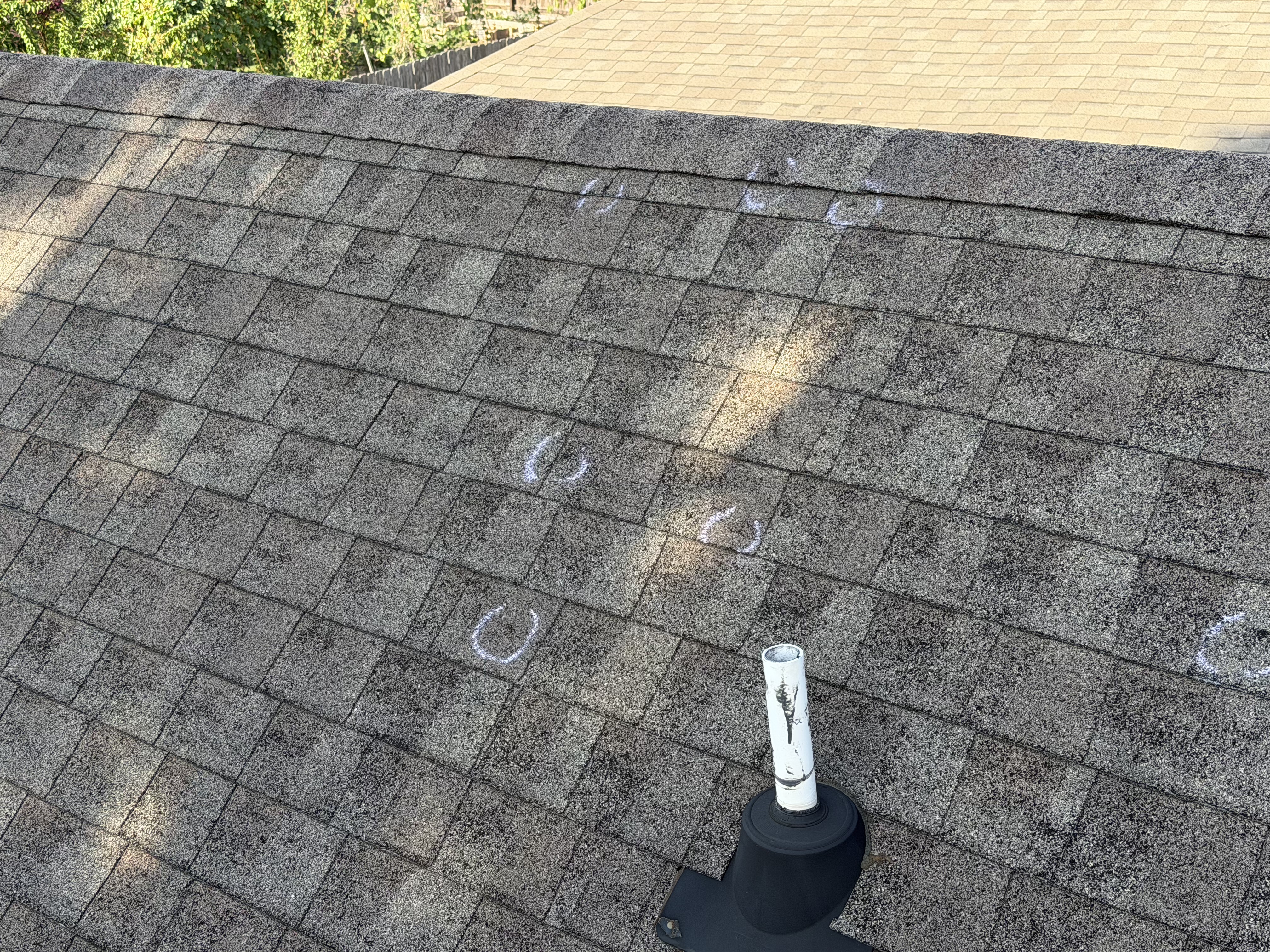 Hail impact marks documented during a storm damage roof inspection