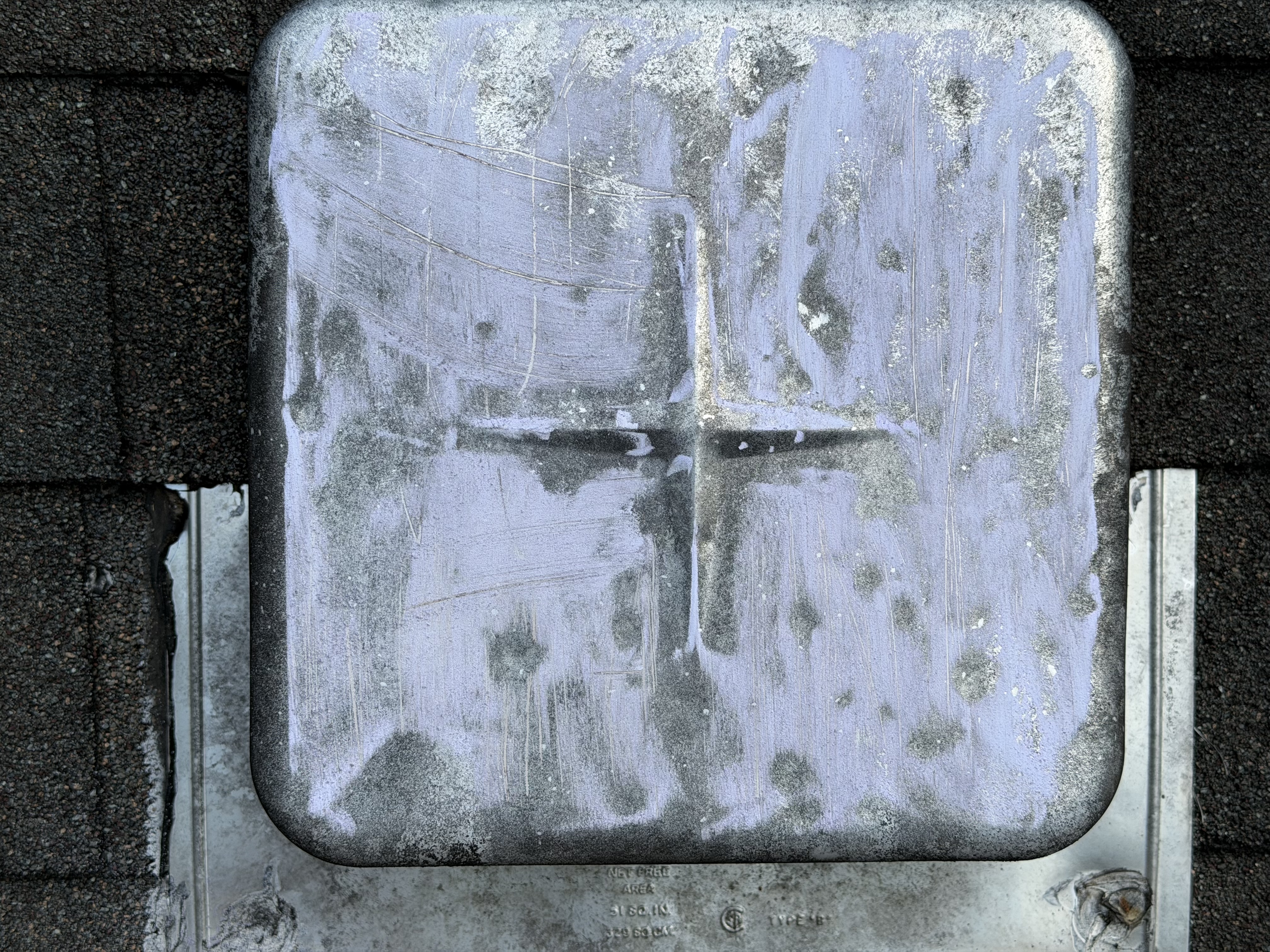 Aging metal roof vent with peeling sealant found during inspection