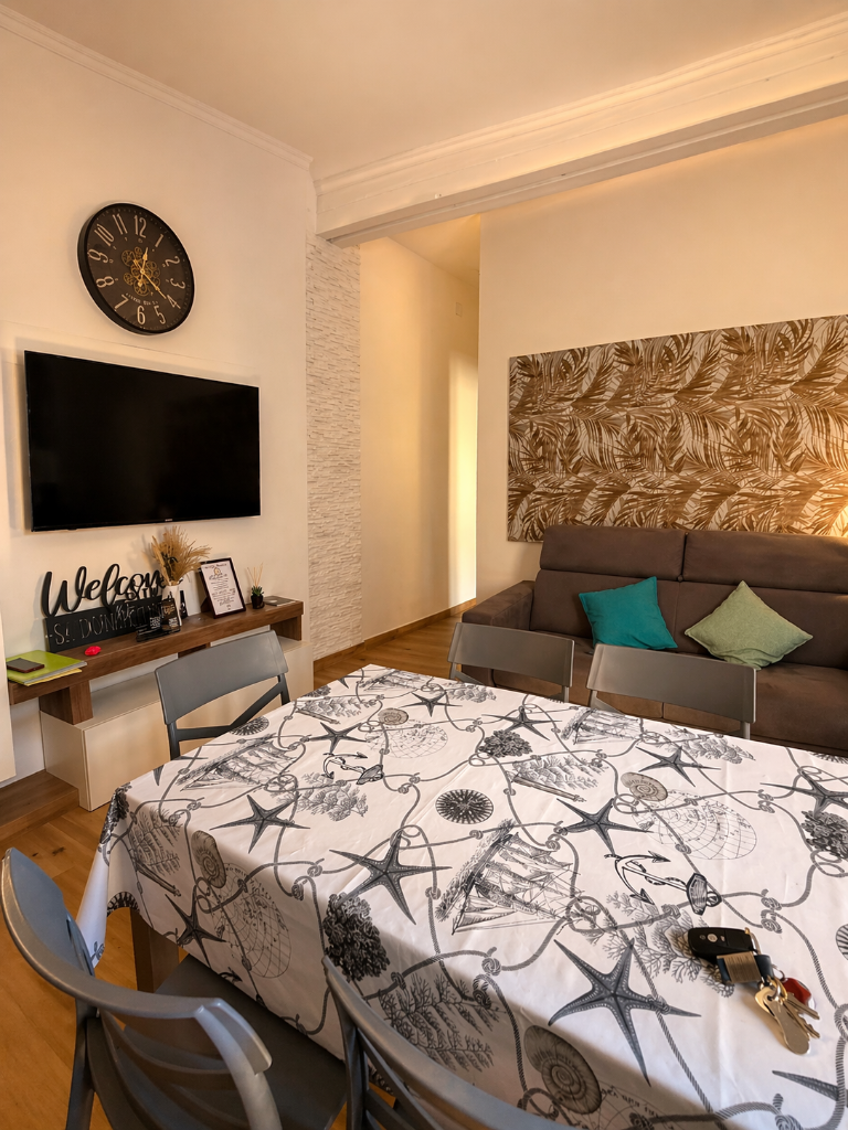 Tavolo con tovaglia a stelle marine, divano e Smart TV