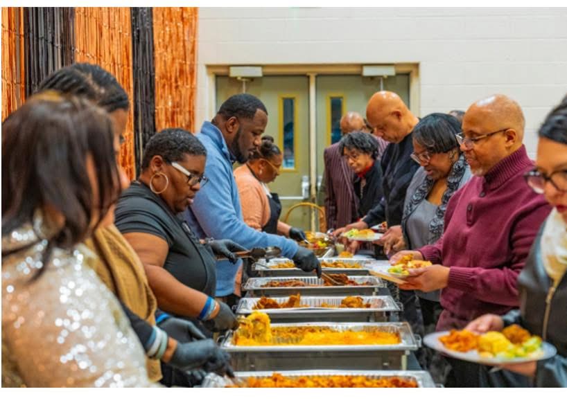 Volunteers serving meals and helping families during a community outreach event