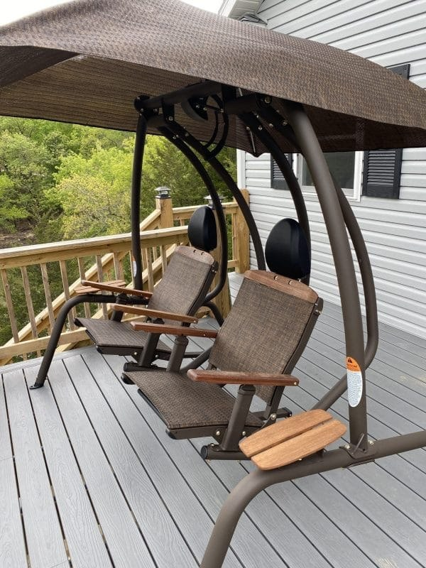 Sunset Swings 422SB Dual Recliner with two sling seats, black headrests, teak armrests, side tables and backrest trim beneath a brown canopy on a deck