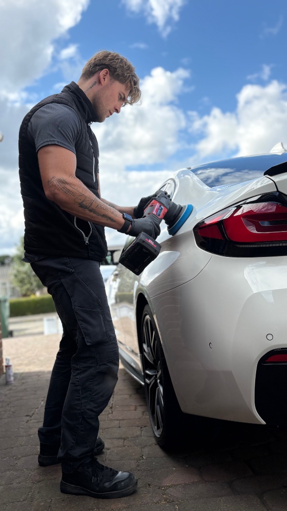 Machine polishing a luxury vehicle during paint correction