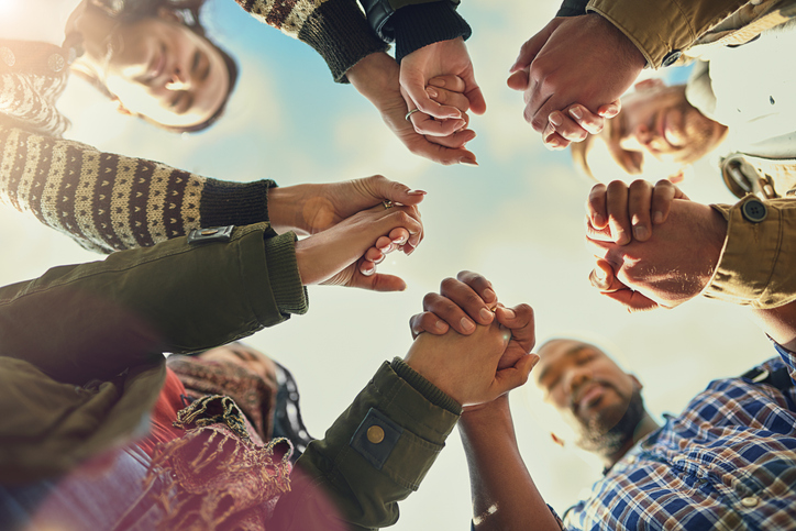 Colorful illustration of diverse hands raised with hearts, symbolizing community and hope