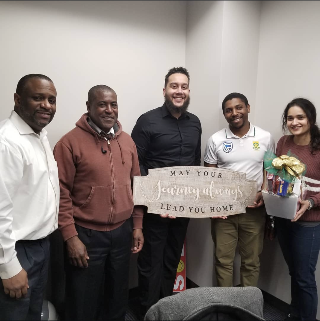 Lance Hawkins with clients holding a 'Lead You Home' sign