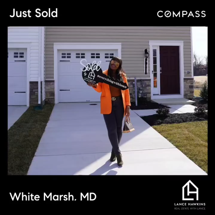 A client holding a sold key in front of her new home