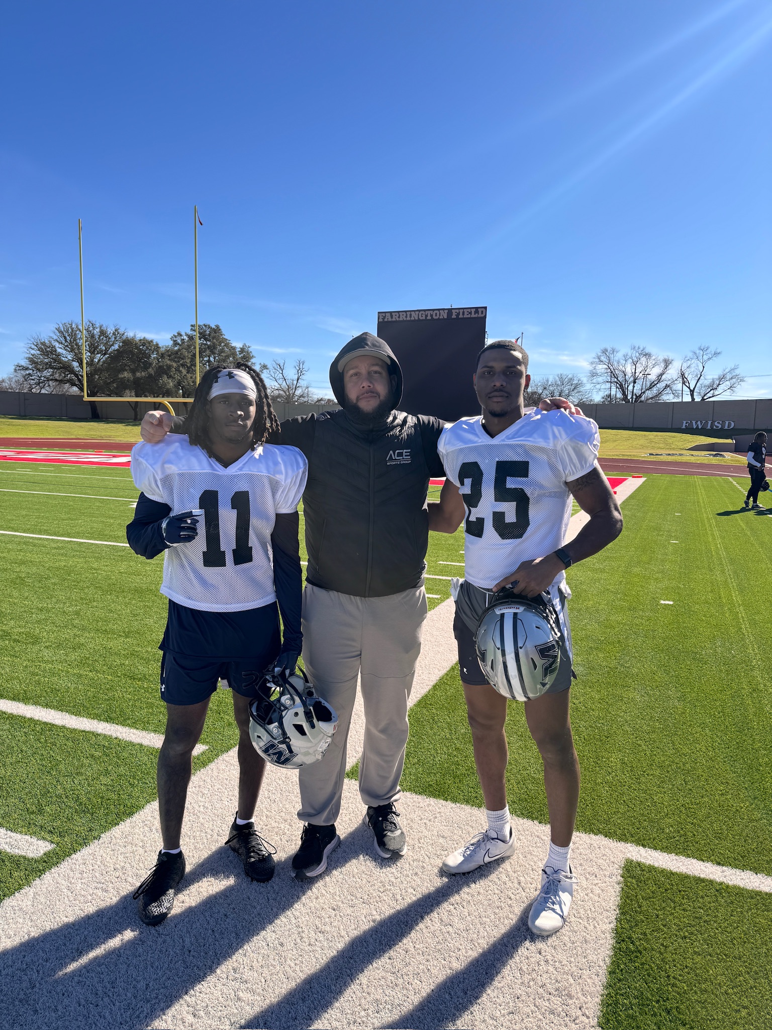Lance Hawkins on the field with two football players