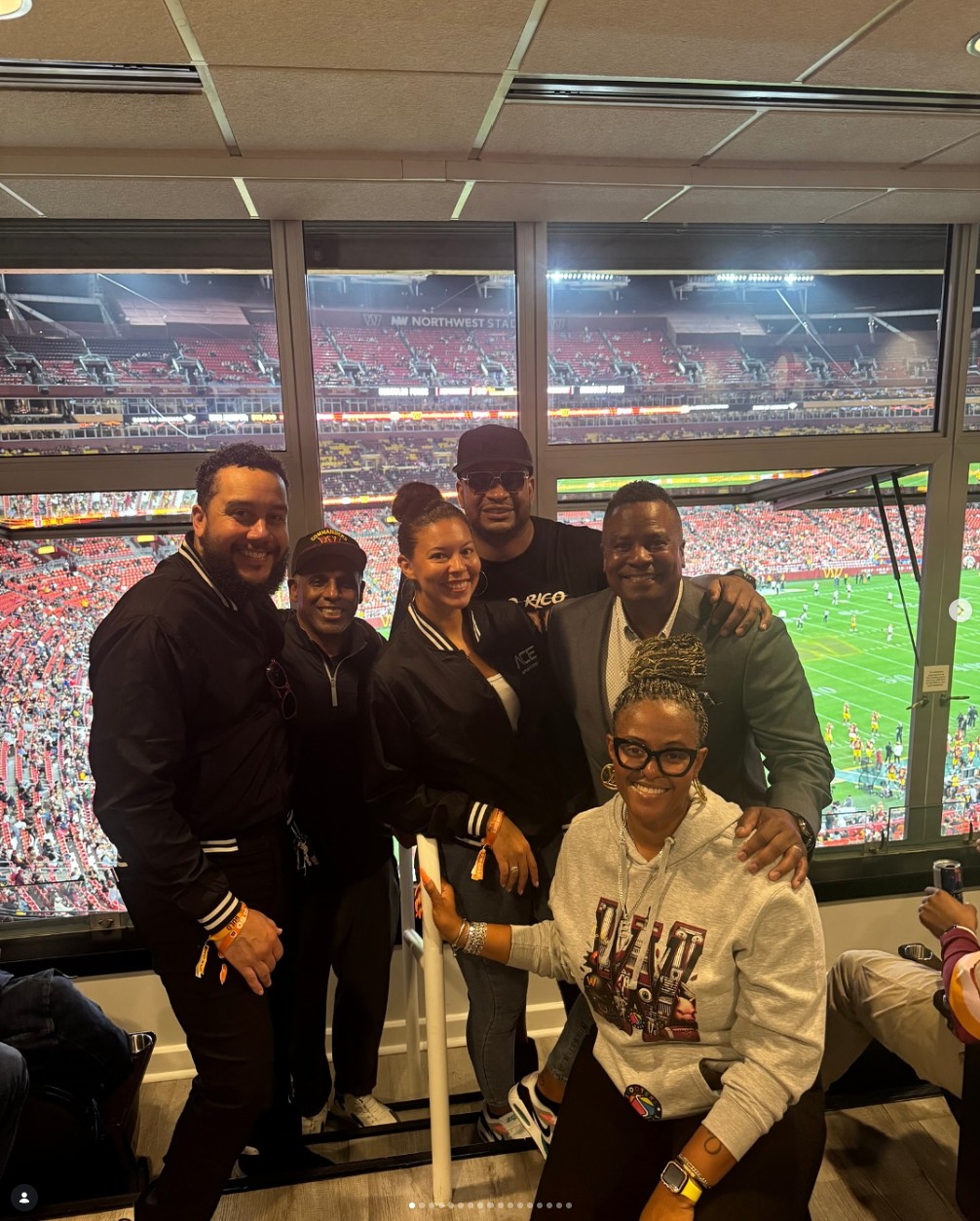 Lance Hawkins with a group in a stadium suite during an NFL game