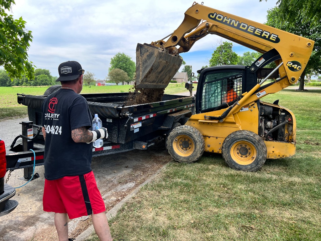 Skid steer loading a dump trailer