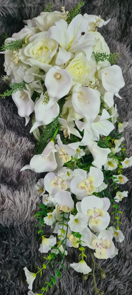 Lush bridal bouquet of garden roses and trailing greenery in golden hour light