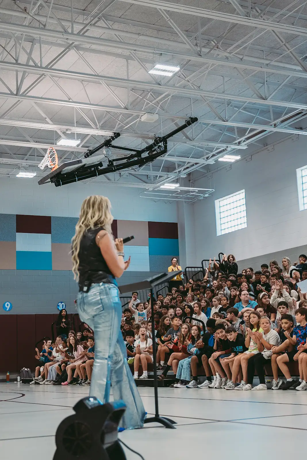 Kate Watson performing for students in a school gymnasium