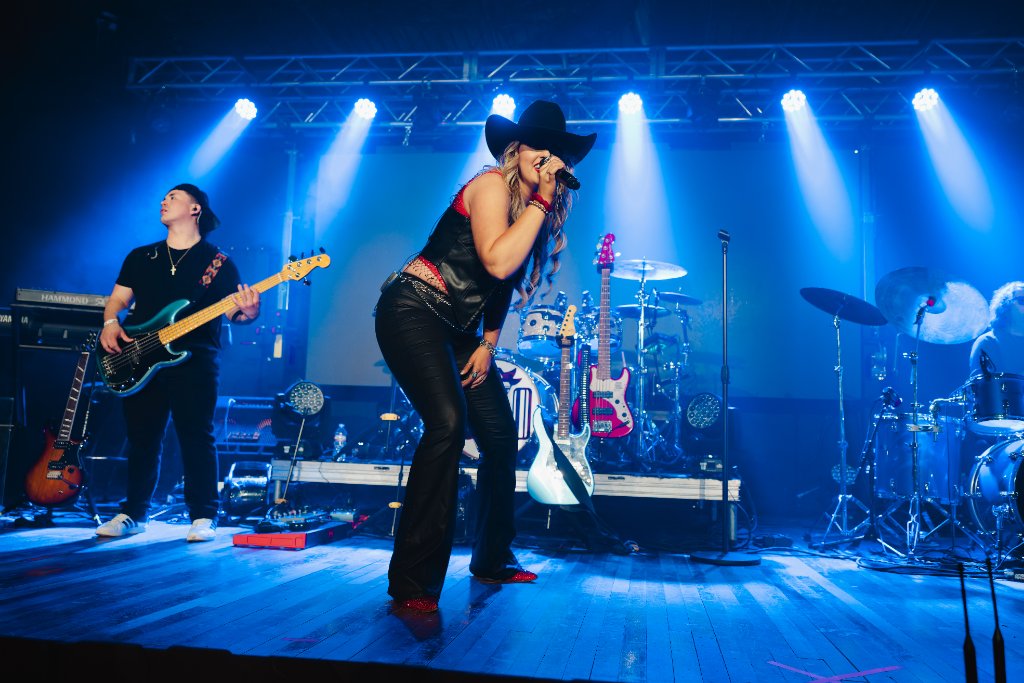 Kate Watson performing with band on stage