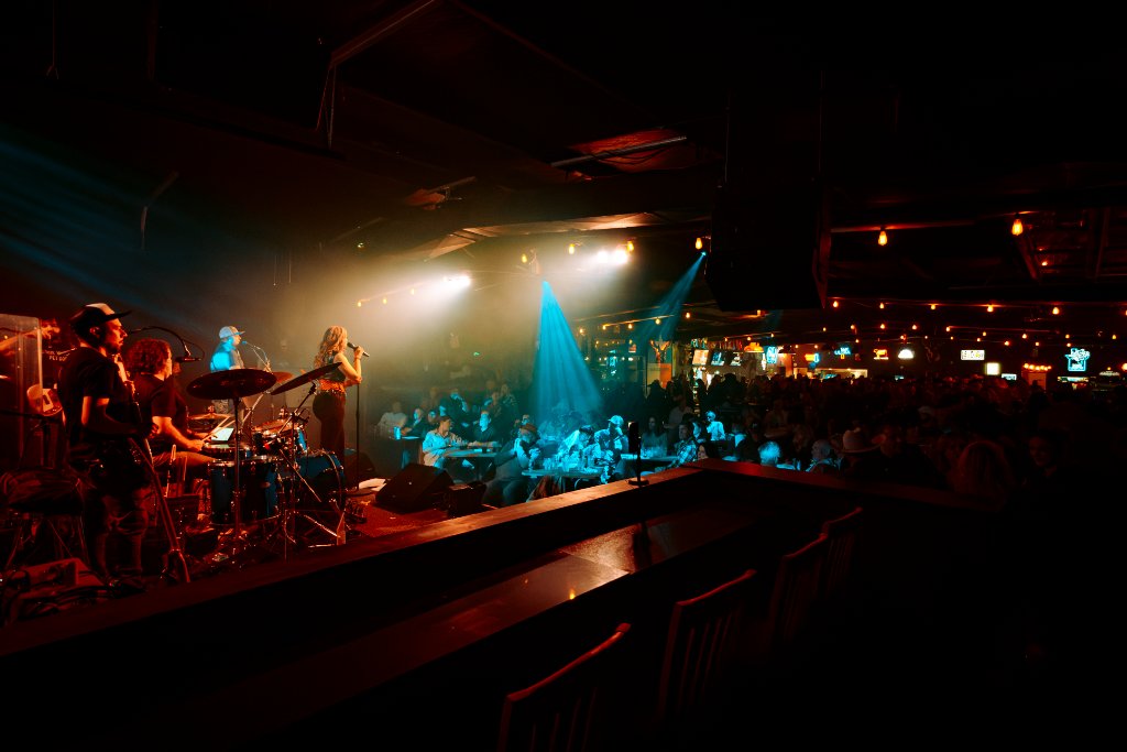 Kate Watson and band performing at a packed venue
