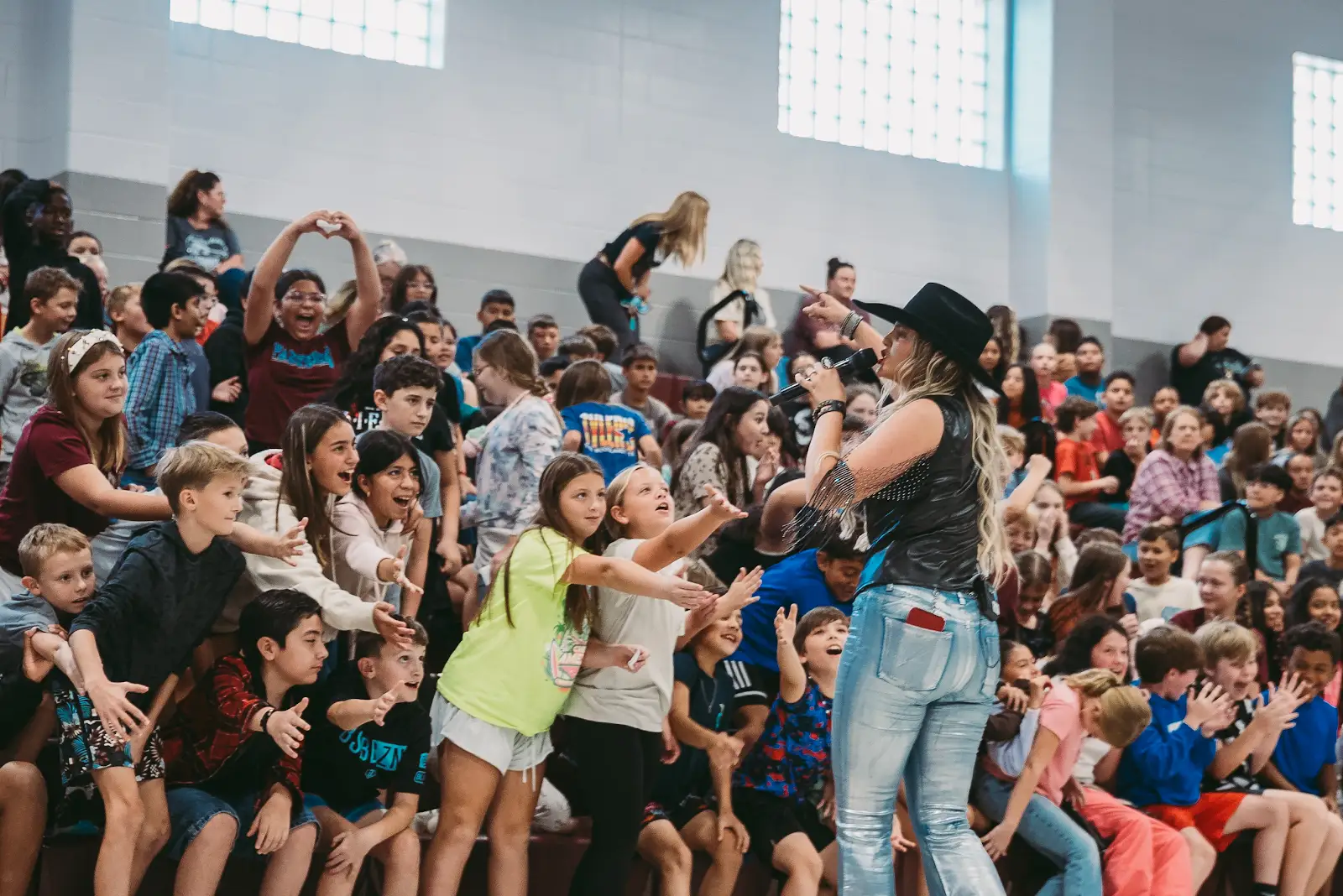 Kate Watson performing live for a gymnasium full of students