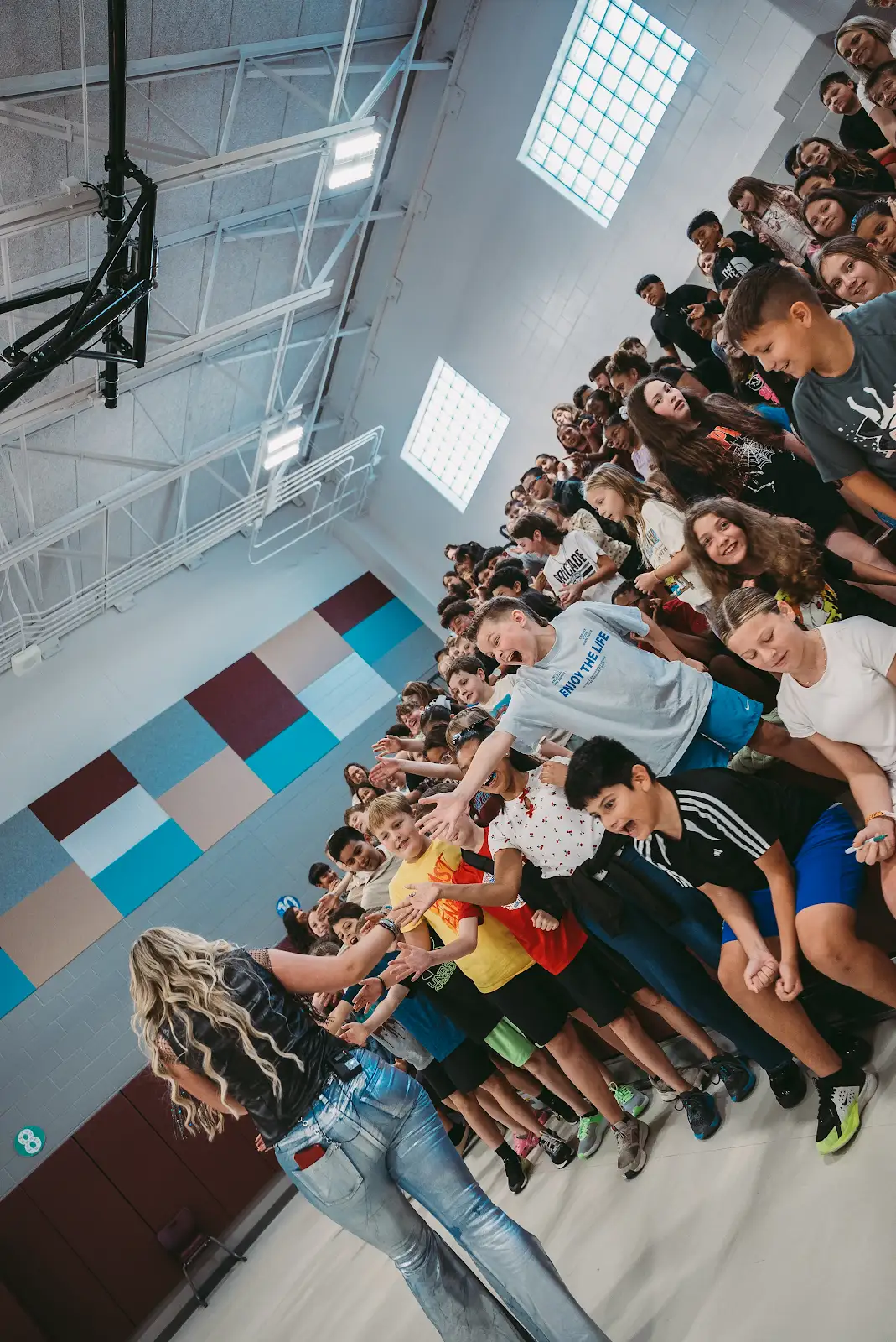 Kate Watson reaching out to high-five students on the bleachers