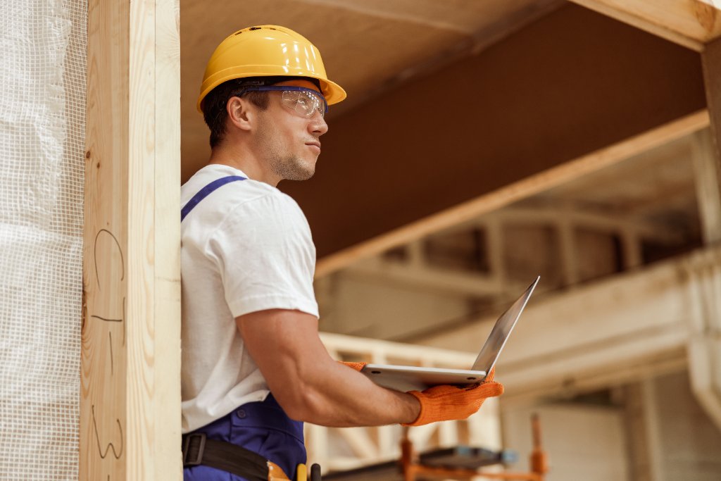 Worker using laptop at construction site