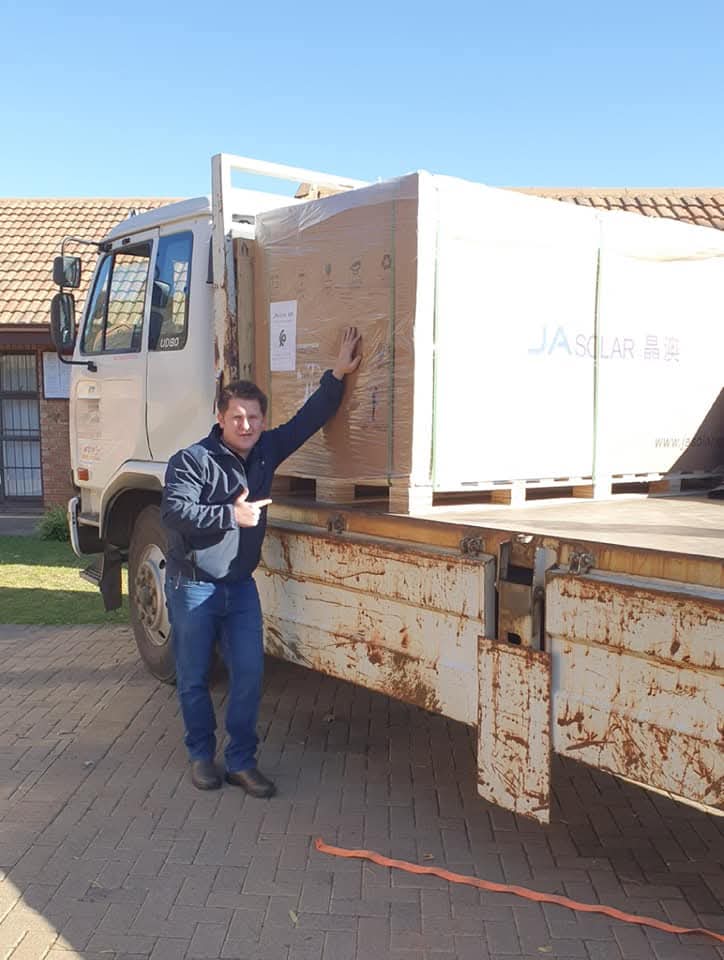 Duane carrying solar panels installation Bloemfontein