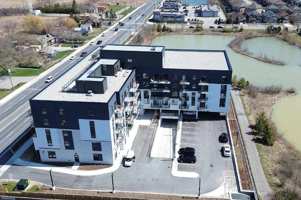 Aerial side view of building with pond
