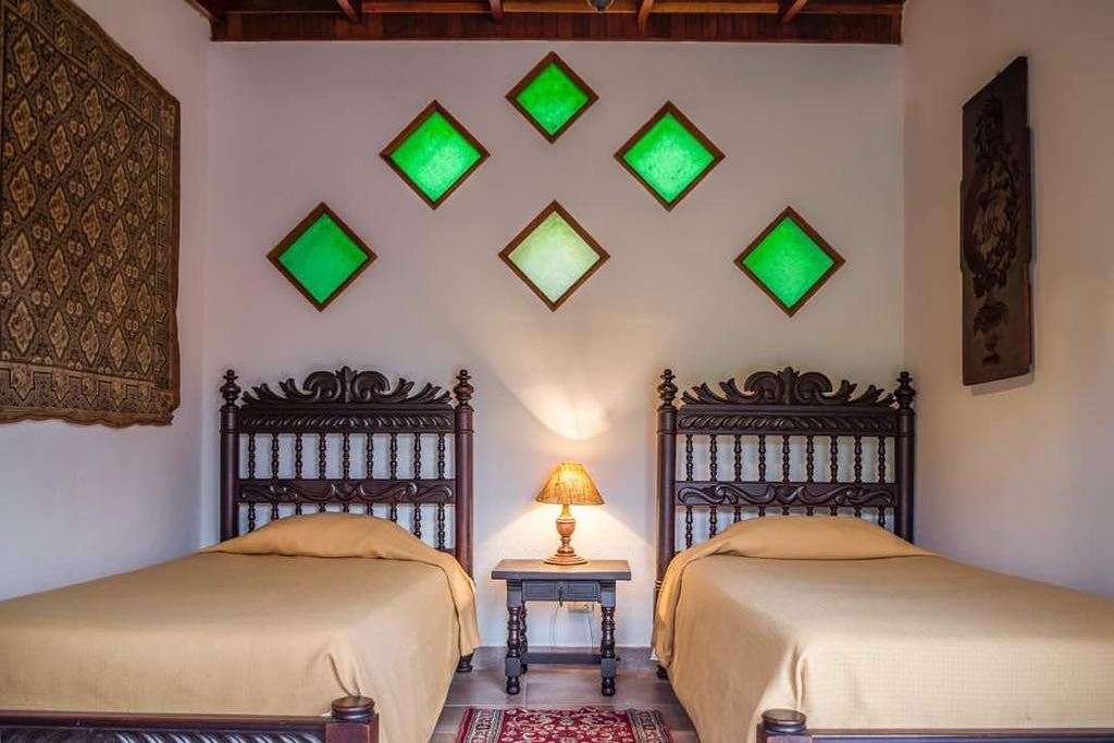 Habitación con dos camas estilo colonial