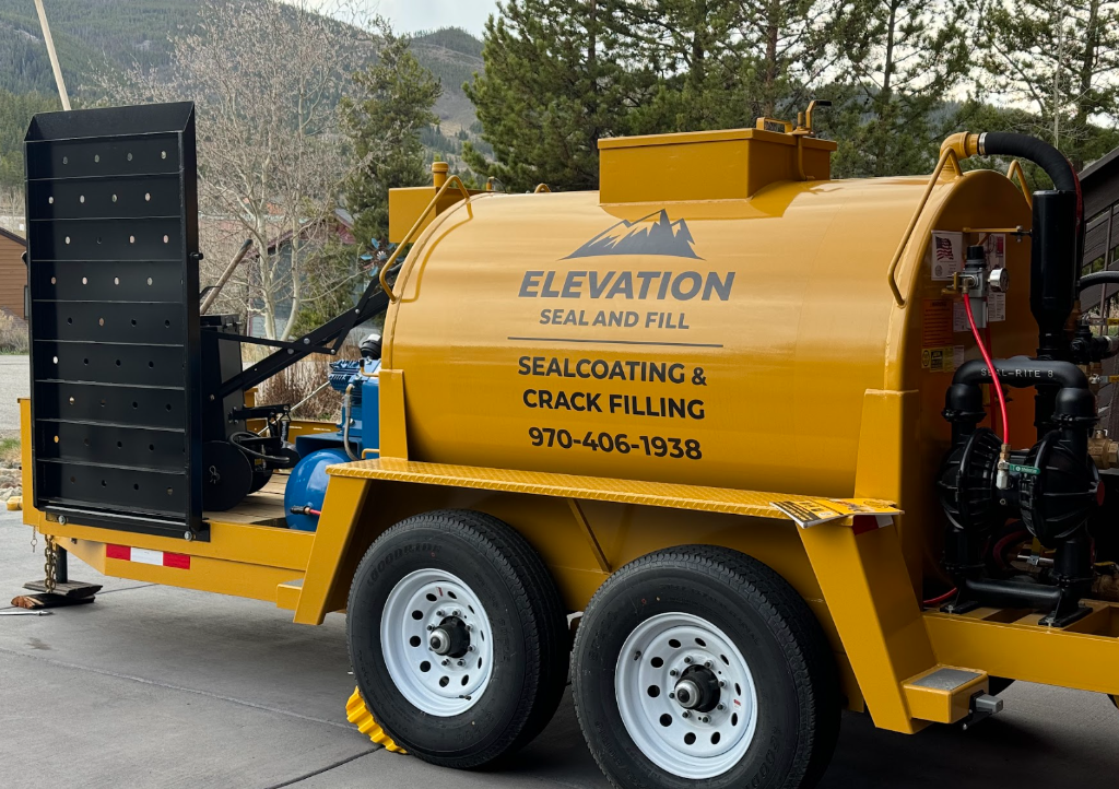 Freshly sealed black asphalt driveway in Summit County Colorado with mountain peaks in background