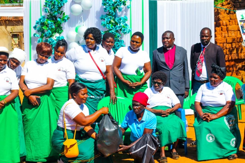 Group of women in white polo shirts and green skirts gathered for a community program in Malawi