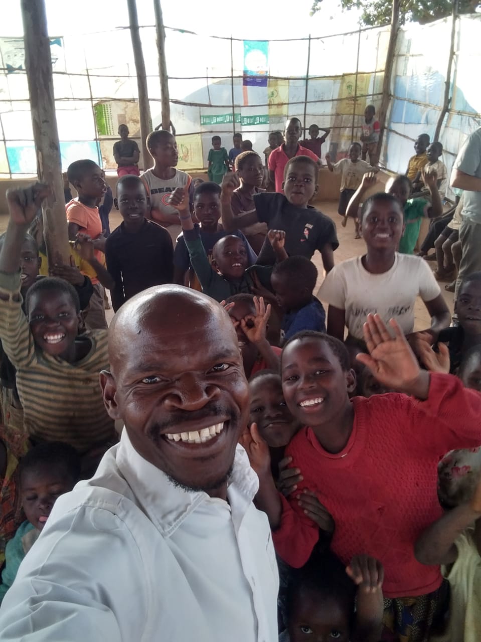 Pastor Edward surrounded by school children during a community program in Malawi