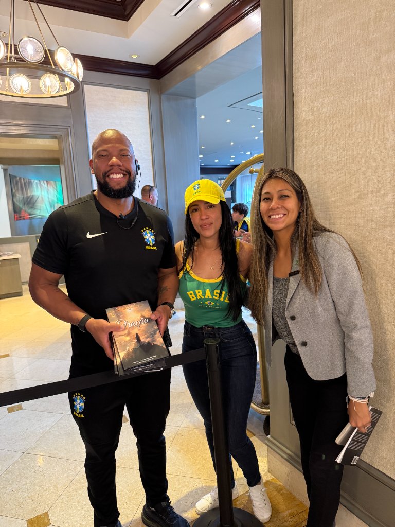 Stefania Leão with team members holding copies of Oração during the 2026 World Cup