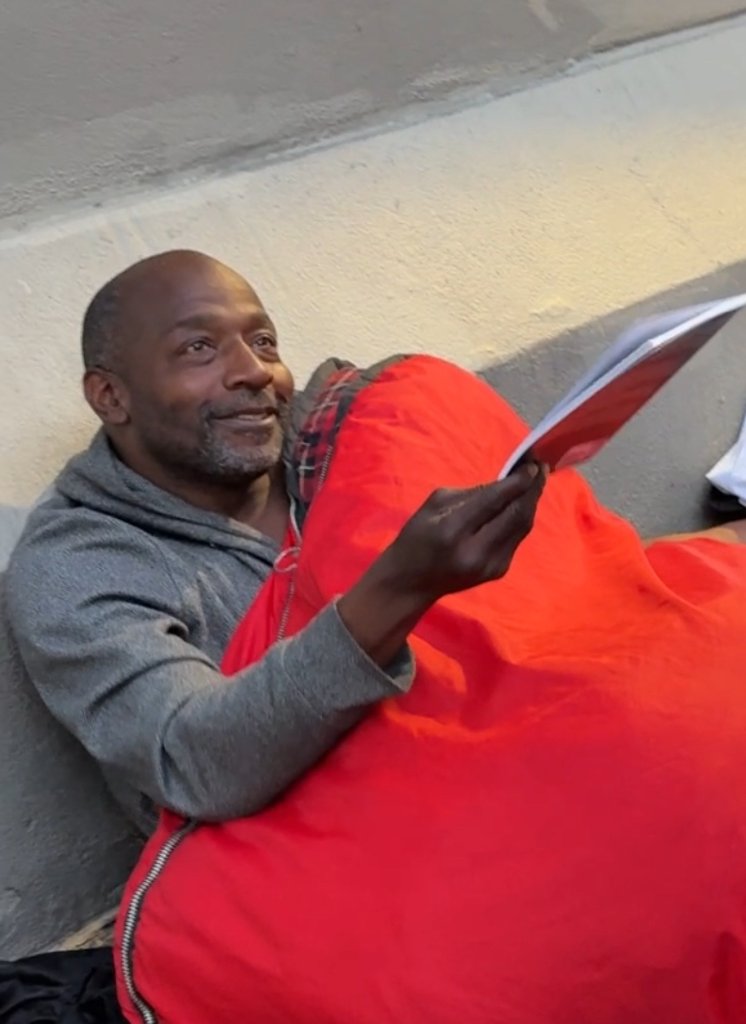 A neighbor holding a copy of The Prayer during San Francisco outreach