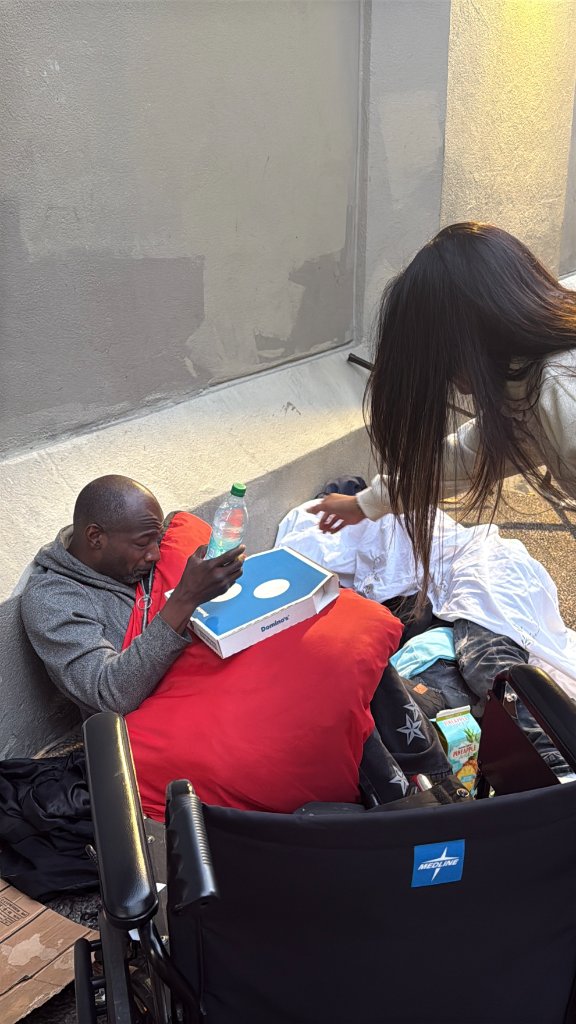 Stefania giving copies of The Prayer to neighbors experiencing homelessness