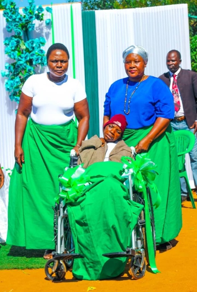 A woman in a wheelchair surrounded by community members during the women's empowerment program