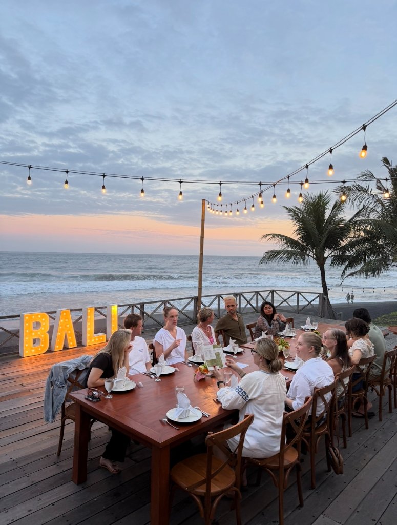 Beachside group dinner — BALI sign